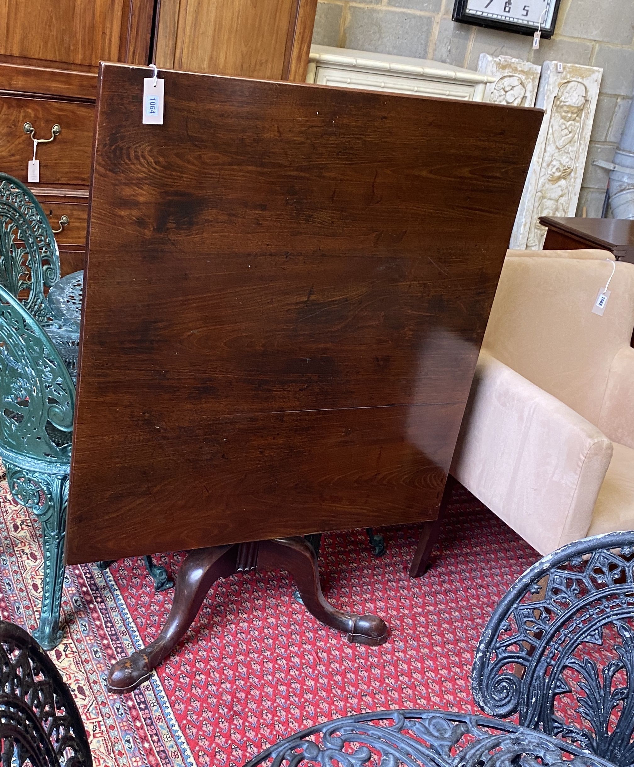 A George III mahogany tilt top breakfast table, formerly a central section of a larger table, width 90cm, depth 96cm, height 72cm